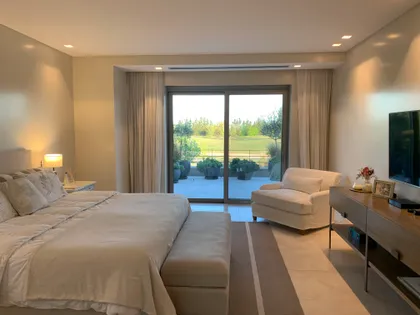 Dormitorio moderno con amplios ventanales y vista al campo — proyecto Casa DF, por Estudio Junor, en Tigre