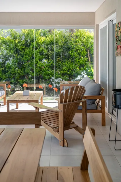 Patio moderno con paredes de vidrio y muebles de madera — proyecto Campo grande III, por Juarez-Fevre Estudio de Arquitectura , en Buenos Aires