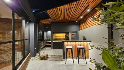 Quincho moderno con techo de listones madera, barra y taburetes — proyecto Timeless House, por Estudio UFV72, en B1602 Florida