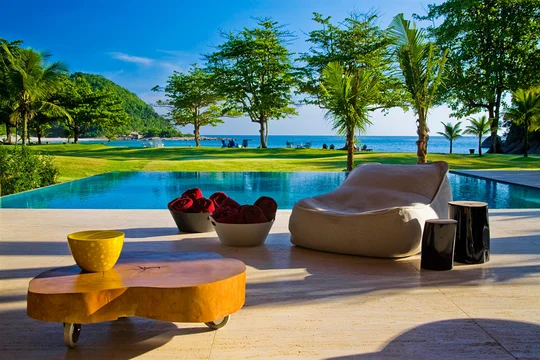 Patio con pileta, deck y jardín frente al mar con árboles — proyecto Arquitetura e Interiores I, por Demian Golovaty