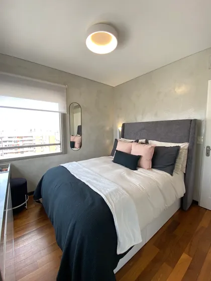 Dormitorio moderno con paredes de microcemento texturizado y cama azul marino y blanca — proyecto Bustamante, por MDBK Arquitectura, en Palermo