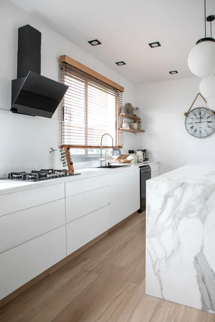 Cocina moderna con isla de mármol y campana angular negra — proyecto Obra El Encuentro, por Arq. Lourdes Yarade Saravia, en Benavidez