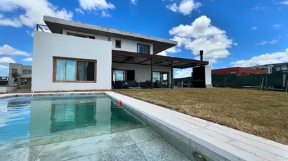 Casa moderna con piscina y deck de madera, fachada blanca — proyecto CASA VIRGI (BARRIO SAN SEBASTIÁN) GERMAN SALAS ARQUITECTURA, por German Salas arquitectura - San Isidro, en Bel