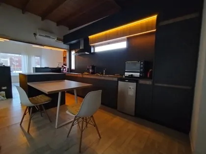Cocina moderna con isla y comedor integrado, terminaciones negras — proyecto Diseño personalizado a gusto del cliente , por Saavedra Amoblamientos , en Pinamar