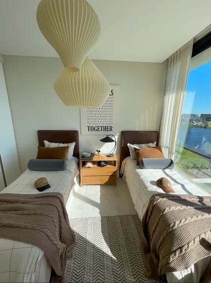 Dormitorio moderno con dos camas, grandes ventanales y lámpara colgante — proyecto El Secreto, por Grupo Pauta Arquitectura, en Tigre