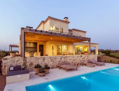 Fachada moderna con piscina en entorno rural al atardecer — proyecto Casa MF, por Estudio Junor, en Belén de Escobar