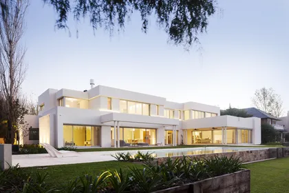 Fachada moderna blanca con ventanales y piscina — proyecto Modernismo Náutico, por Apaarquitectura, en Tigre