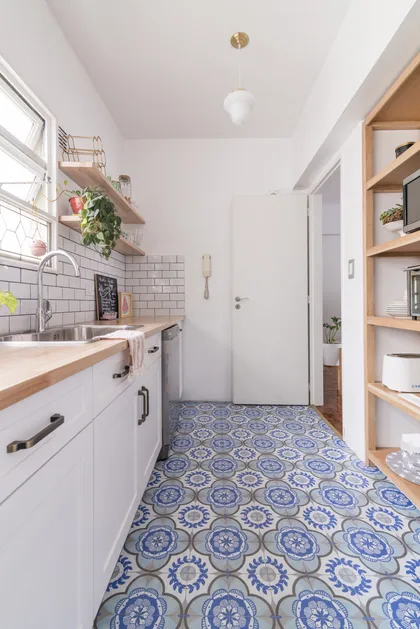 Cocina moderna con piso de baldosas azules y blancas, y muebles blancos — proyecto S Bustamante 2, por ST Arquitectas, en CABA
