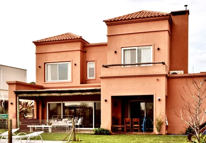 Casa moderna terracota con grandes ventanales y galería al jardín — proyecto Santa Teresa, Villanueva, por Marconi Silva Arquitectos, en Benavidez