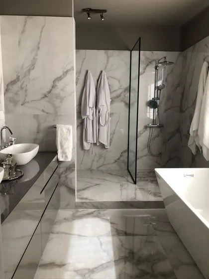 Baño moderno con mármol, bañera exenta y ducha de cristal — proyecto Casa Nordelta, por Etude Interiorismo, en Nordelta