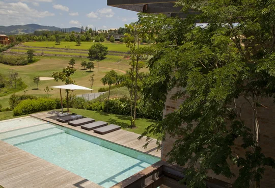 Casa moderna con pileta, deck y vista al campo verde — proyecto Residência MP, por Gil Fialho