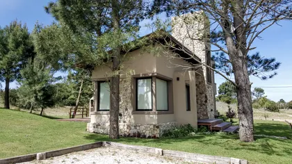 Fachada rústica moderna con piedra, ladrillo y grandes ventanales — proyecto Vivienda Multifamiliar en Las Gaviotas, por Estudio Schifano, en Canning