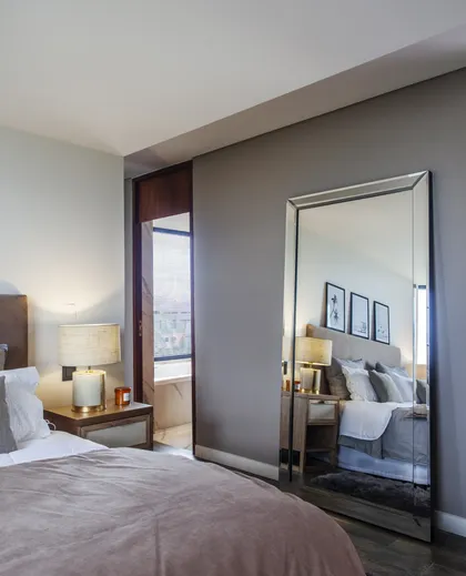 Dormitorio moderno con espejo de cuerpo entero y luz cálida — proyecto Casa BJM, por Vanguarda Arquitectos, en Belén de Escobar