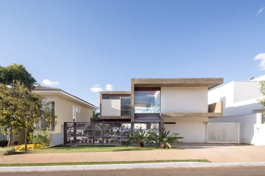 Casa contemporánea con fachada blanca, celosía de madera y amplios ventanales — proyecto Casa Bentes, por Coda Arquitetos