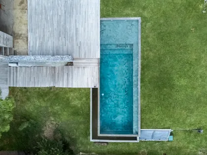 Piscina moderna con deck de madera y césped circundante — proyecto CASA sobre el MAR, por Guerrero Arquitectos, en Pinamar