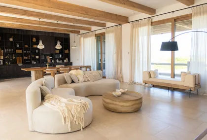 Living moderno con vigas de madera y sofá curvo — proyecto El Refugio, por Grupo Pauta Arquitectura, en Pinamar