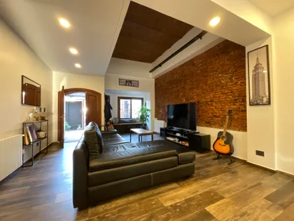 Living moderno con pared de ladrillo expuesto y sofá seccional — proyecto JUAN AGUSTIN GARCIA, por Novoa Clerici arquitectos, en Buenos Aires