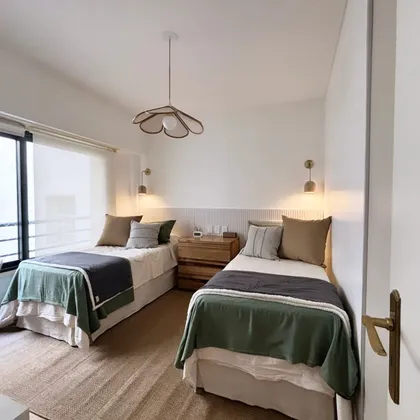 Dormitorio con dos camas y detalles boho — proyecto Uruguay, por Claraboia , en Recoleta