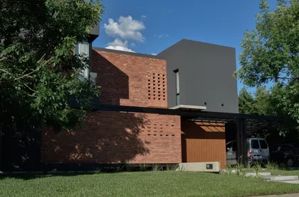 Fachada moderna de ladrillo y hormigón con grandes ventanales — proyecto CASA HC, por Daniel Daniele - Oficina de Arquitectura, en Canning