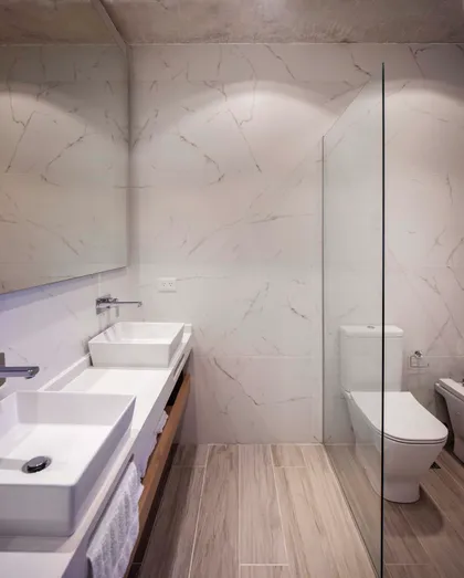 Baño moderno con paredes de mármol, dos bachas y detalles minimalistas — proyecto DISEÑO INTERIOR - CASA VISTAS, por FOCO_arquitectura&diseñointerior, en Belén de Escobar