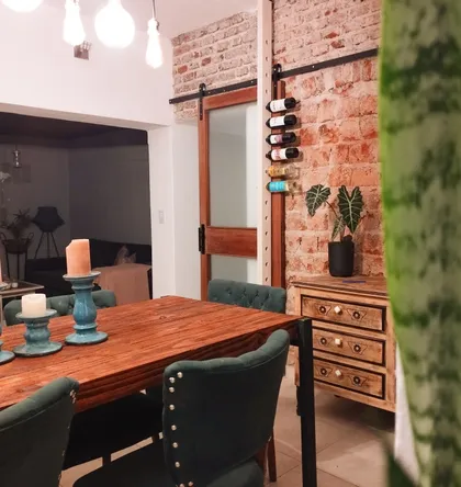 Comedor rústico-industrial con ladrillo expuesto y mesa de madera — proyecto Comedor, por Deva, en Córdoba
