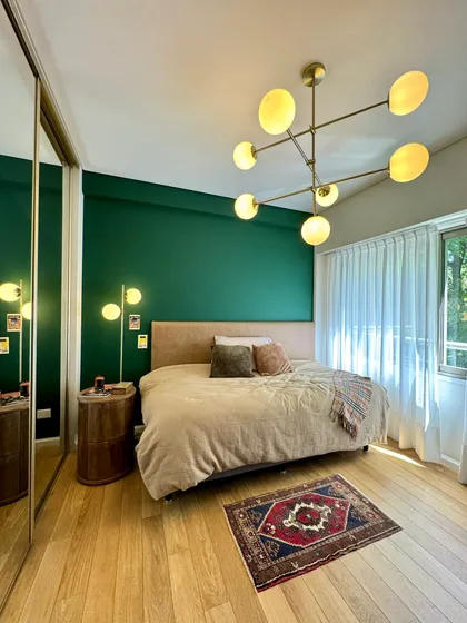 Dormitorio moderno con pared verde, lámpara sputnik y alfombra oriental — proyecto Olleros, por MDBK Arquitectura, en Belgrano