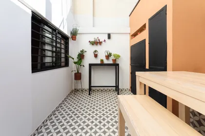 Balcón con plantas, mesa y sillas, azulejos y pared terracota — proyecto Obra Aguirre, por SYA Arquitectas, en Palermo