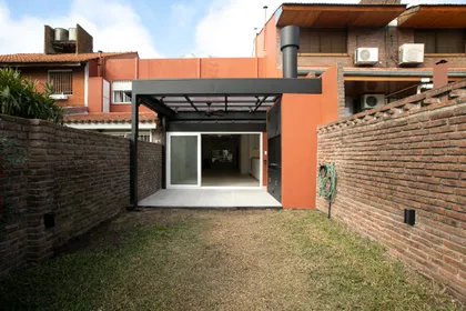 Fachada moderna industrial con pérgola negra y ladrillo — proyecto Obra Martinez A, por Arq. Lourdes Yarade Saravia, en Martínez