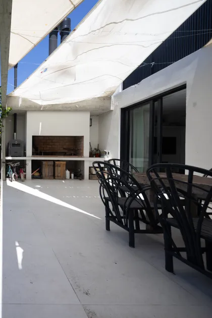 quincho moderno con toldo blanco y sector de parrilla — proyecto CASA OrBa, por Alfredo Orfila arquitectura, en San Isidro