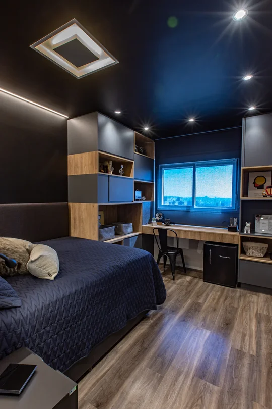 Dormitorio moderno con cama azul, escritorio y estantería de madera — proyecto Duo Morumbi 2, por Pricila Dalzochio
