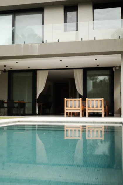 Casa moderna con piscina y terraza de madera — proyecto Casa MV, por Vidal Bianchi arquitectura, en Pilar