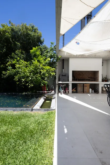 espacio exterior moderno con piscina, parrilla y toldo de tela — proyecto CASA OrBa, por Alfredo Orfila arquitectura, en San Isidro