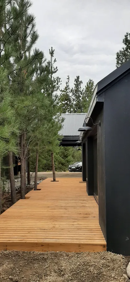 Fachada moderna con deck de madera y entorno boscoso — proyecto Casa LA MOROCHA, por Showhouse Bariloche, en San Carlos de Bariloche