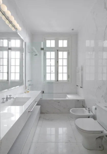 Baño moderno minimalista con mármol blanco y grandes ventanas — proyecto Dpto AY, por Estudio Dado, en Recoleta