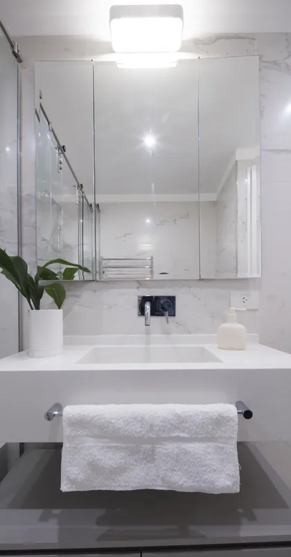 Baño moderno minimalista con mármol, espejo grande y planta — proyecto Uriburu, por Parq Estudio, en CABA