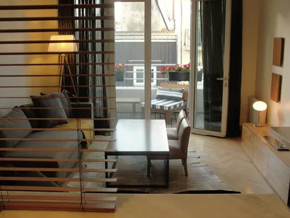 Living moderno con paredes de madera y grandes ventanales — proyecto Departamento JD, por Vicky Hurrell, en Mar del Plata