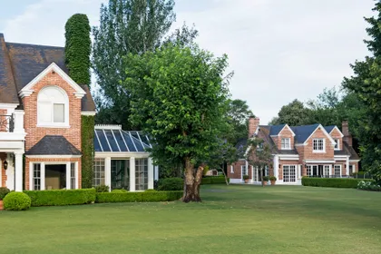 Mansión clásica de ladrillo con jardín verde impecable y árboles — proyecto Casa Tortugas , por Estudio Du , en Tortugas Country Club