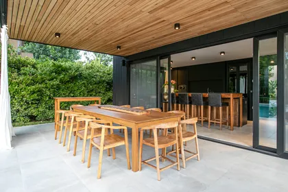 Quincho moderno con mesa de madera, sillas y techo de listones — proyecto ARQ. LOURDES YARADE SARAVIA, por uchimayfotos