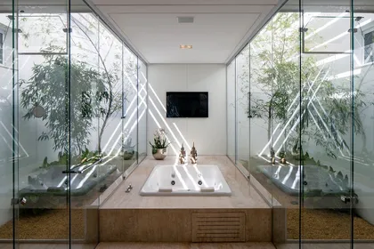 Baño minimalista con bañera integrada y plantas envolventes — proyecto Casa TB, por Aguirre Arquitetura
