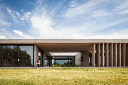 Fachada moderna con pérgola de hormigón y grandes ventanales — proyecto Casa JUMP, por V2 Arquitectos, en City Bell