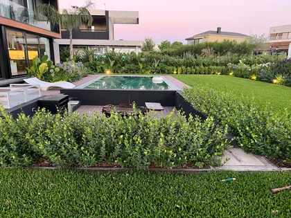 Jardín moderno con piscina, deck de madera y vegetación exuberante — proyecto CAN., por Baires Green, en Canning