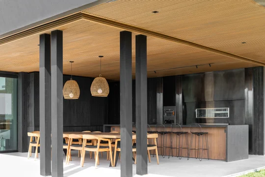 Quincho moderno con cocina integrada, columnas oscuras y techo de madera — proyecto Obra Casa Belair, por lifecycle, en B1648 Tigre