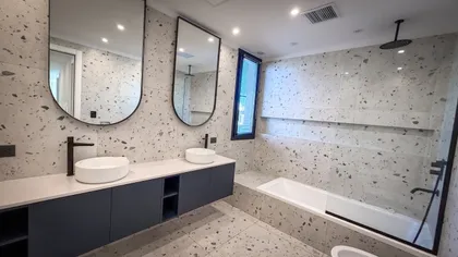Baño moderno con paredes y suelo de terrazo, dos lavabos ovales y grifería negra — proyecto Yatch 278, por CIFARELLI arquitectos, en Tigre