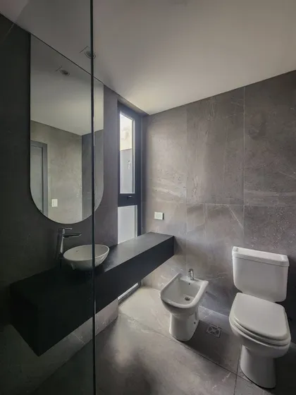 Baño moderno con bidet, inodoro y lavabo sobre mesada flotante — proyecto San Sebastian 318, por BARBALACO ARQUITECTOS, en Pilar