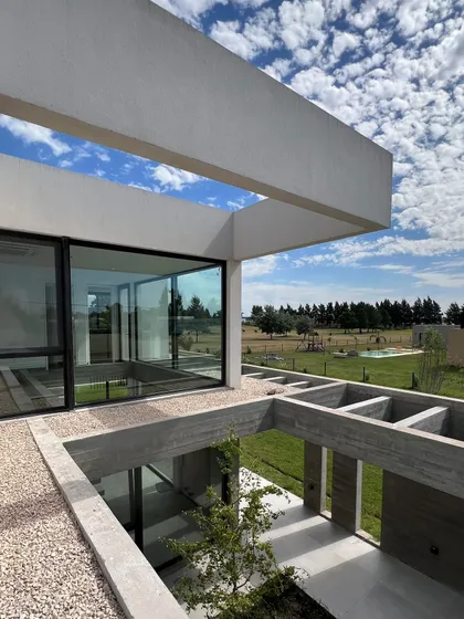 Terraza moderna con pergola, vista a campo y piscina al fondo — proyecto Casa Golf, por RY Construir Estudio, en San Vicente