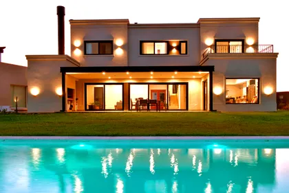 Fachada moderna con piscina iluminada y deck de madera — proyecto Casa CG191, por EZ architects, en Belén de Escobar