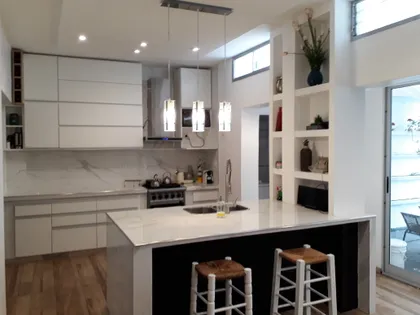 Cocina moderna minimalista con isla central y detalles de mármol — proyecto Remodelación cocina 8, por Zima Arquitectura, en La Plata