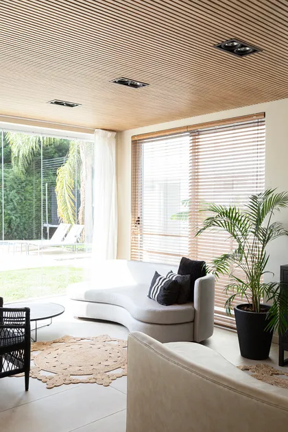Living moderno con techo de listones de madera y sofá curvo — proyecto Proyecto Gaby P. , por LINEA NETA diseño interior , en Canning