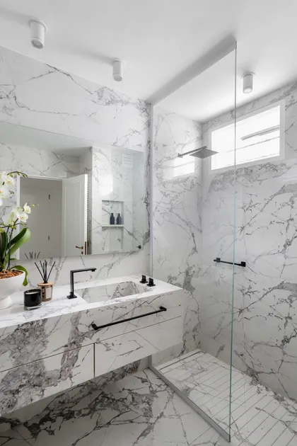 Baño moderno con mármol veteado, lavabo integrado y grifería negra — proyecto Alvear | Redefining luxury, por Ren Studio, en Recoleta