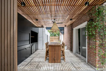 Comedor exterior con techo de madera y ladrillo expuesto — proyecto Obra La Posta, por Arq. Lourdes Yarade Saravia, en Pilar